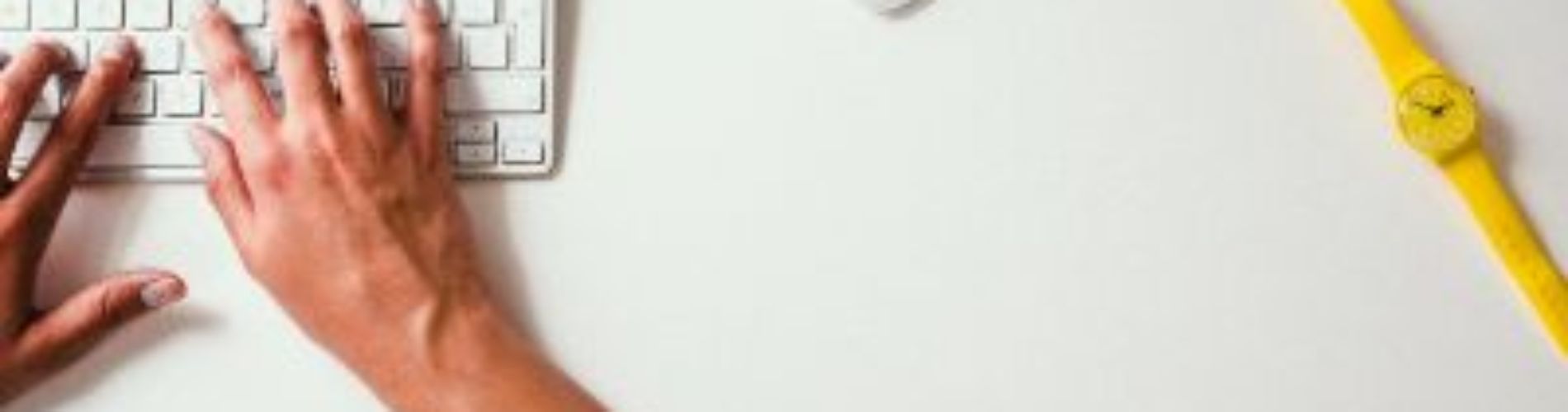 scrivania con persona che usa tastiera e mouse